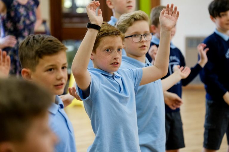 Key stage 2 pupils engaged in drama workshop in school hall