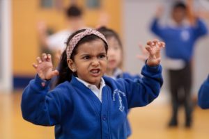 primary school pupils at a drama workshop in school hall