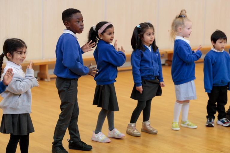 Key stage 1 pupils engage in a drama workshop in their school hall