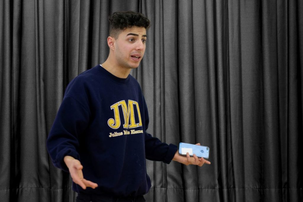 School drama workshop actor holds mobile phone exploring the theme of online safety and sexting